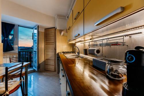 a kitchen with a counter and a large window at Sunsets at the Palace in Bucharest