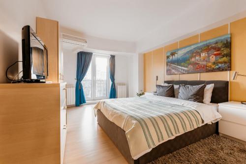 a bedroom with a bed and a flat screen tv at Sunsets at the Palace in Bucharest