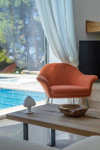 an orange chair sitting on a table in front of a window at VILLA ROSA MEDITERRANEA in Marina di Pescoluse