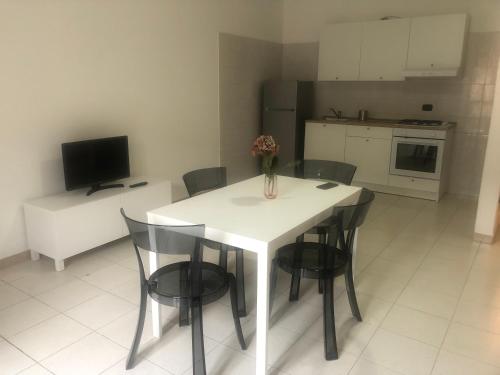 a kitchen with a white table and black chairs at Grazioso bilocale in centro in Tagliacozzo