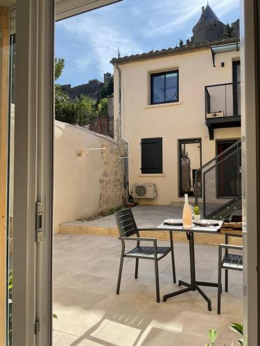 eine Terrasse mit einem Tisch und Stühlen sowie ein Gebäude in der Unterkunft Studio pour 2 avec terrasse au pied de la Cité : ma pierre à l’édifice in Carcassonne