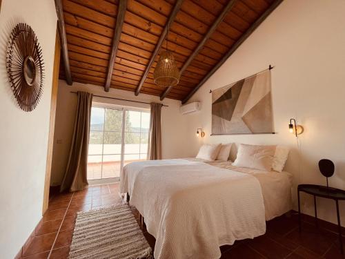 1 dormitorio con cama y ventana grande en Casa Colinas Roxas by Portucasa, en Quelfes