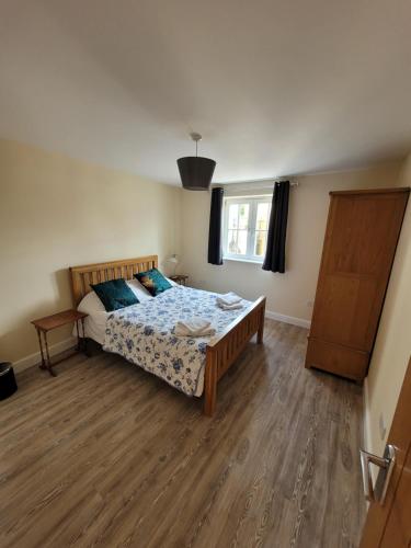 a bedroom with a bed and a wooden floor at Milton Court in Sittingbourne