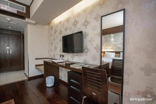 a room with a bed and a mirror and a television at Mark Inn Hotel Deira in Dubai