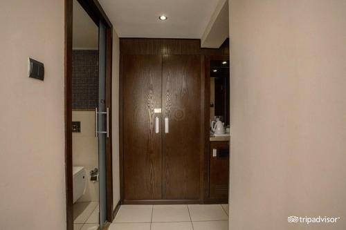 a bathroom with a wooden door and a sink at Mark Inn Hotel Deira in Dubai
