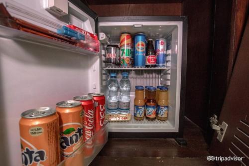 an open refrigerator filled with cans and bottles of soda at Mark Inn Hotel Deira in Dubai