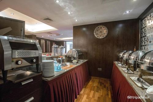 a large kitchen with a counter in a restaurant at Mark Inn Hotel Deira in Dubai