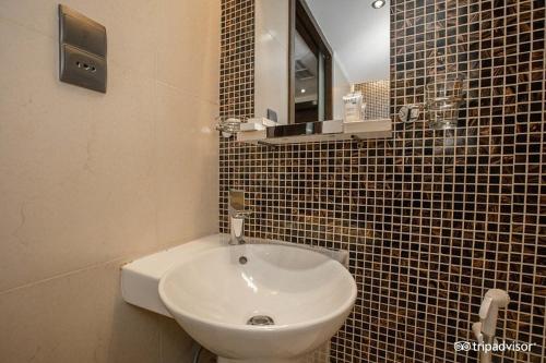 a bathroom with a white sink and a mirror at Mark Inn Hotel Deira in Dubai