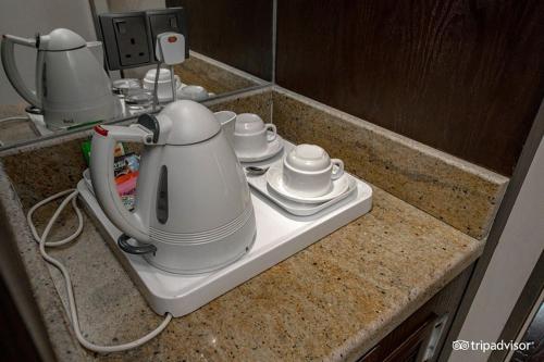 a kitchen counter with a tea kettle and cups at Mark Inn Hotel Deira in Dubai