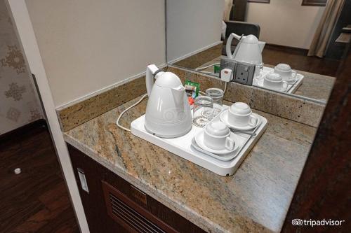 a kitchen counter with cups and a tea set on it at Mark Inn Hotel Deira in Dubai