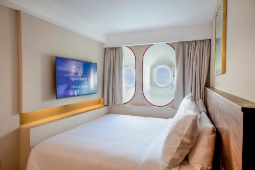 a bedroom with a bed and a window in an airplane at Queen Elizabeth 2 Hotel in Dubai