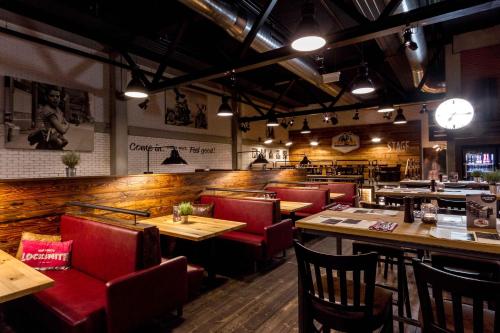 a restaurant with wooden tables and red chairs at Zündwerk - Motel in Strasshof an der Nordbahn