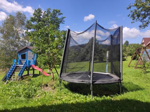 a trampoline in the grass next to a playground at Apartamenty Madzia in Wisła