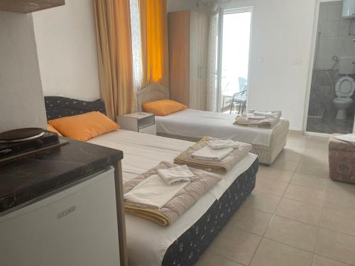 a room with two beds with towels on them at Apartmani Jacimovic in Čanj