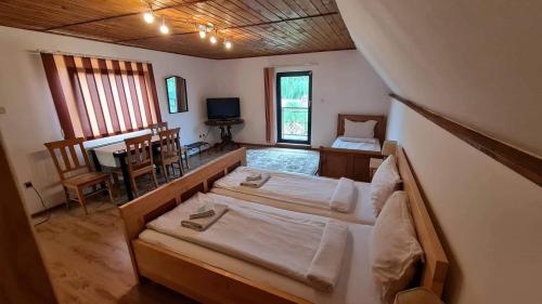 シギショアラにあるPensiunea Otiliaのベッドルーム1室(ベッド2台、テーブル、デスク付)