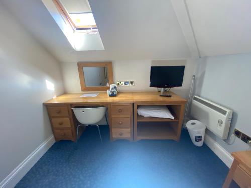 Zimmer mit einem Schreibtisch, einem Computer und einem TV. in der Unterkunft Ibis Budget Bromsgrove in Bromsgrove