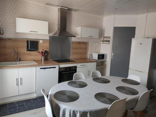 a kitchen with a table and a kitchen with white cabinets at l arbre à chats in Saint-Martin-de-Brômes