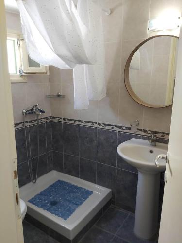 a bathroom with a shower and a sink and a mirror at Annezina's memories in Logaras