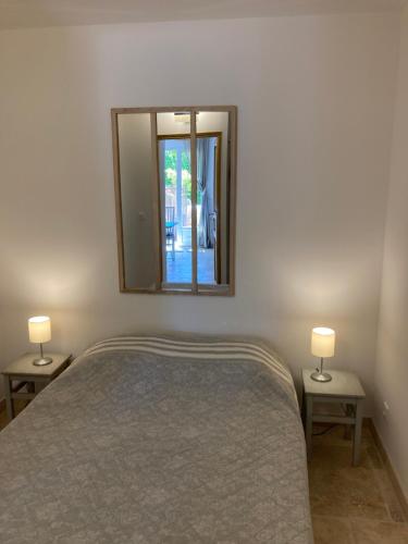 a bedroom with a bed and a mirror on the wall at Cabanon Ecurie Maestoso in Lançon-Provence