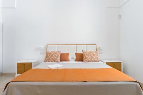 a bedroom with a large bed with orange pillows at VILLA ROSA MEDITERRANEA in Marina di Pescoluse