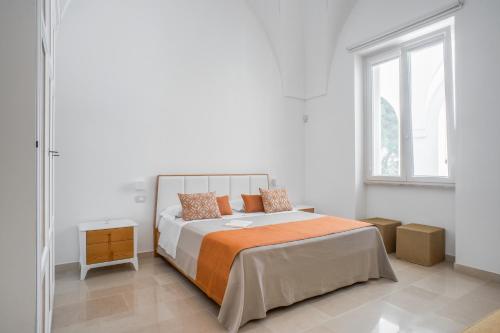 a white bedroom with a bed and a window at VILLA ROSA MEDITERRANEA in Marina di Pescoluse