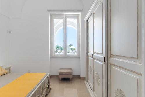 a white room with a bed and a window at VILLA ROSA MEDITERRANEA in Marina di Pescoluse