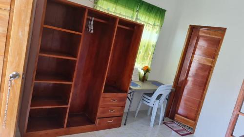 a room with a desk and a wooden book shelf at Babas Guesthouse in Moalboal
