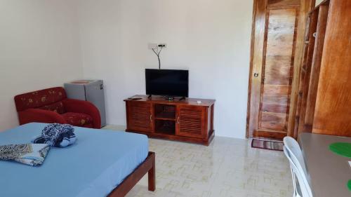 a living room with a tv and a couch and a table at Babas Guesthouse in Moalboal