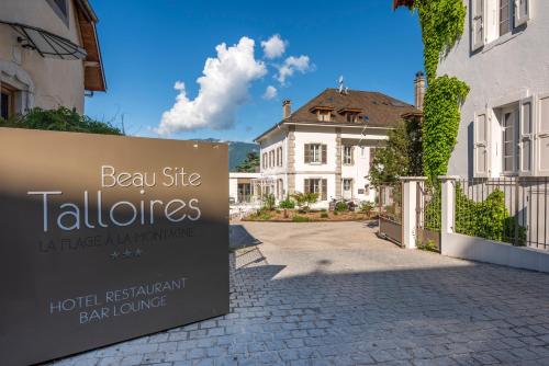 a sign for a hotel in front of a building at Hôtel Beau Site Talloires B SPA in Talloires