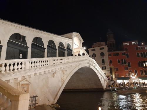 un pont sur une rivière dans une ville la nuit dans l'établissement Foscà Venice Rooms, à Venise