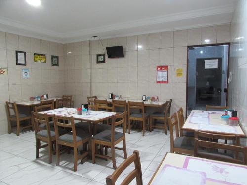 a dining room with tables and chairs and a tv at Teodoro Palace Hotel a 5 minutos do Brás e Bom Retiro in Sao Paulo