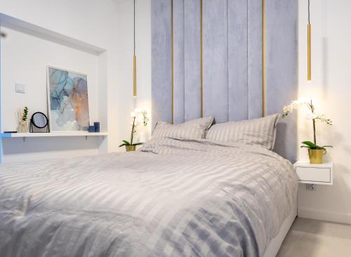 - une chambre avec un lit et une couette bleue et blanche dans l'établissement HORIZON HEVENIA Rewal Apartament z dużym tarasem i widokiem na morze, à Rewal