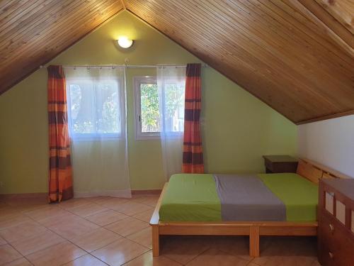 a bedroom with a bed and a window at TiCaze MONTAGNE in Cilaos