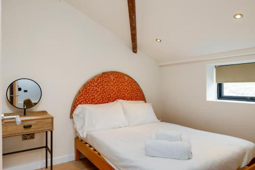 a small bedroom with a bed and a mirror at CoalShed Lofts - Groups -Exclusive Use in Bristol