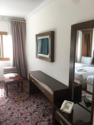 a hotel room with a desk and a bed at Sky View Hotel, Madinah in Al Madinah