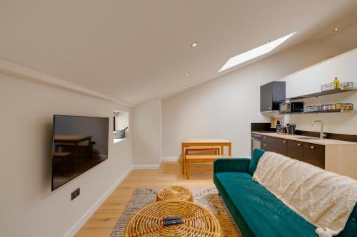a living room with a green couch and a kitchen at CoalShed Lofts - Groups -Exclusive Use in Bristol