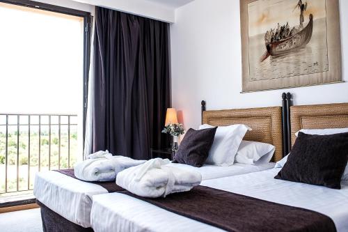 two beds in a hotel room with towels on them at Termes Montbrio Hotel & Spa in Montbrió del Camp