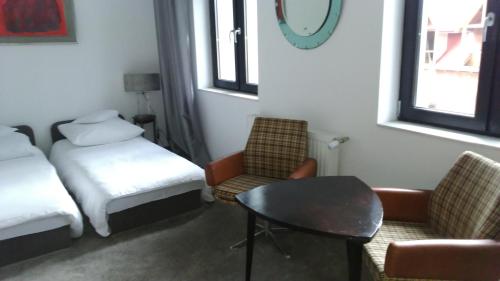 a room with a bed and a table and chairs at Willa Uroboros in Szklarska Poręba