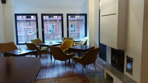 a dining room with tables and chairs and windows at Willa Uroboros in Szklarska Poręba