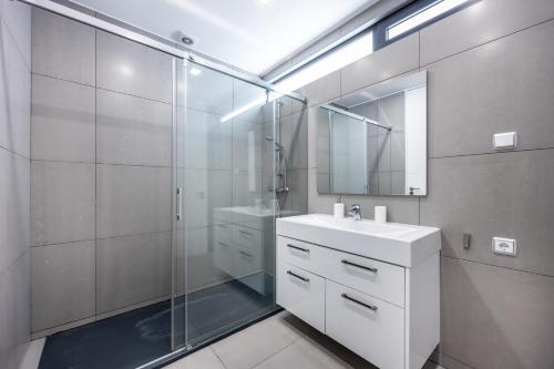 a bathroom with a shower and a sink and a mirror at Villa Figo in Luz de Tavira