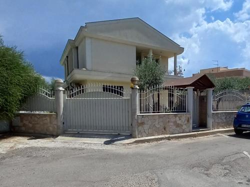 een huis met een hek en een hek bij Miriam Casa Vacanze in Flumini di Quartu