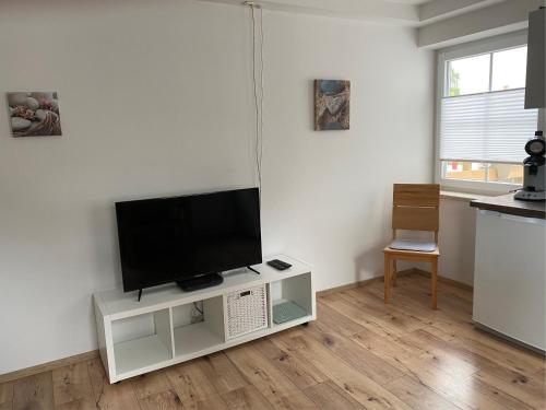 uma sala de estar com uma televisão de ecrã plano num suporte em Heike & Günther Ferienwohnung em Seeg