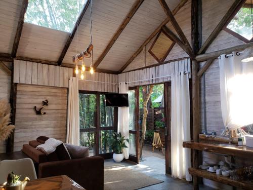 a living room with wooden walls and a ceiling with windows at Cabana em BOSQUE ENCANTADO! in Florianópolis