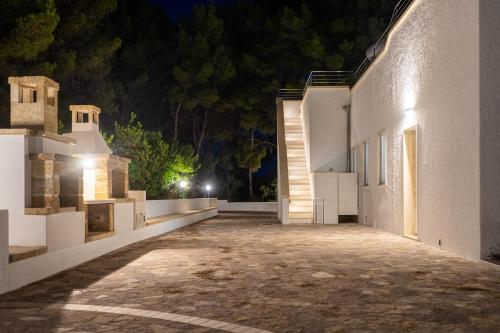 an empty courtyard of a white building at night at VILLA ROSA MEDITERRANEA in Marina di Pescoluse