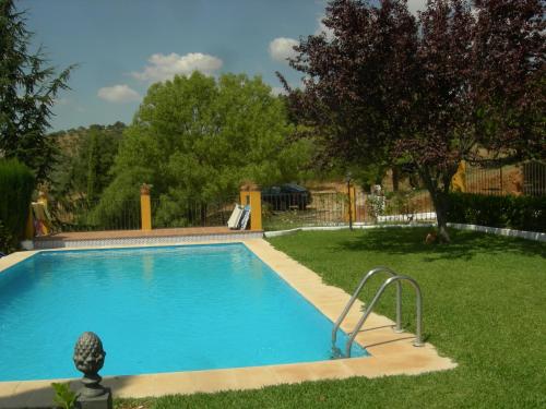 a swimming pool in a yard next to a grass yard at Casa rural Villa Manuela in Cazalla de la Sierra
