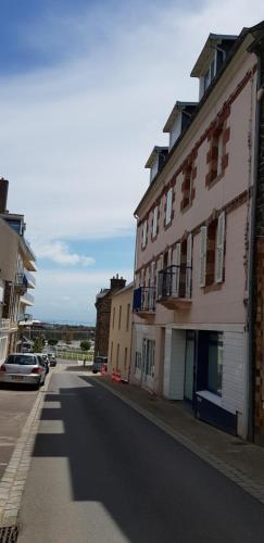 eine leere Straße mit Gebäuden am Straßenrand in der Unterkunft Appartement au pied du port de St Quay Portrieux in Saint-Quay-Portrieux