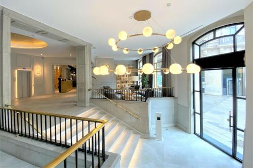 a lobby with a chandelier and stairs in a building at Colón Hotel Barcelona in Barcelona