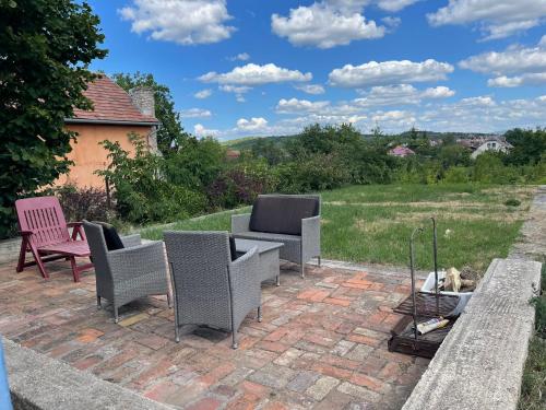 a patio with chairs and a table on a brick patio at LakePark Apartman in Bekecs