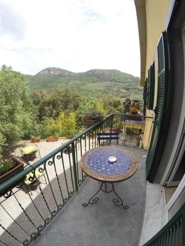 a balcony with a table and a view of the mountains at Ai Cinque Campanili in Finale Ligure