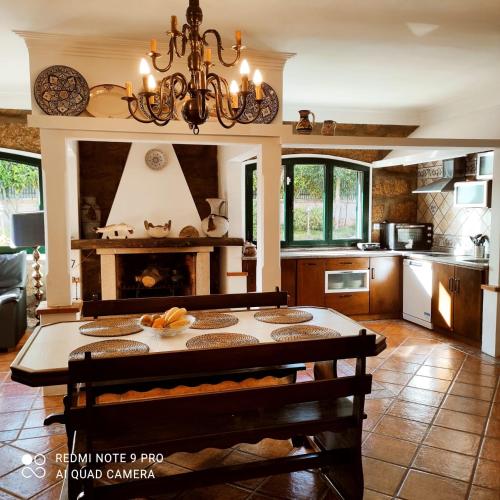a kitchen with a table in the middle of a room at Casa Além Rio - quartos para 6 hóspedes em Santo Tirso in Santo Tirso